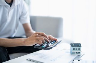 © Charlie's - Adobe Stock.com Foto: Mann tippt auf Taschenrechner