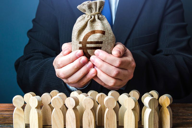 © Andrii Yalanskyi - stock.adobe.com Foto: Mann mit Geldbeutel in den Hände und kleine Holzfiguren stehen davor