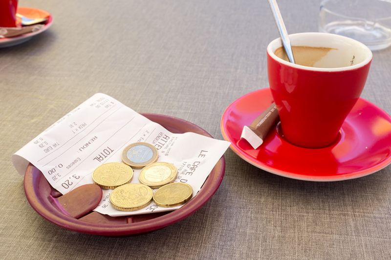 Foto: Kaffeetasse mit Rechnung und Münzen